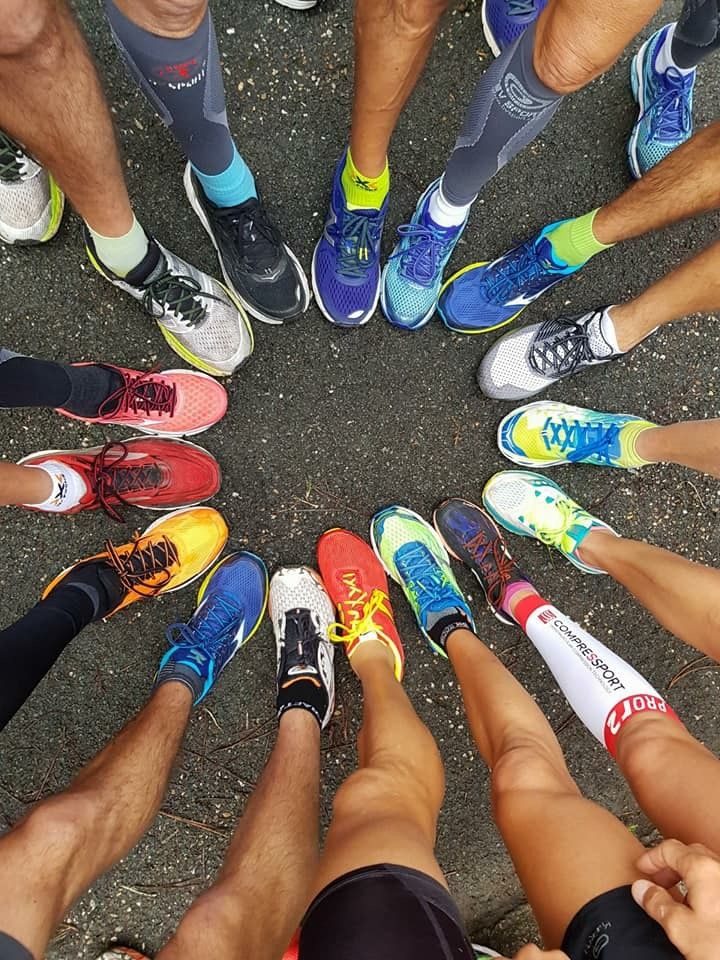 Zapatillas de un club de corredores formando un círculo sobre el asfalto.